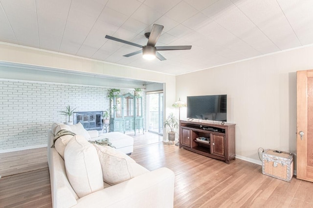 1408 W Clark St, Bartlett, TX 76511 - living room with brick wall, ceiling fan, crown molding, light wood-type flooring, and baseboards