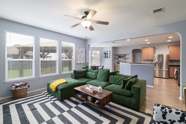 8716 Panadero Dr, Austin, TX 78747 - living room with arched walkways, light wood finished floors, a ceiling fan, and recessed lighting
