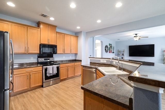 8716 Panadero Dr, Austin, TX 78747 - kitchen with appliances with stainless steel finishes, arched walkways, light wood-style floors, a ceiling fan, and recessed lighting
