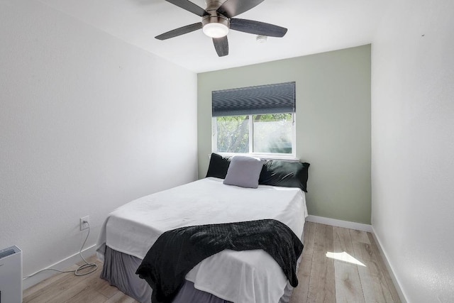 bedroom with light wood-type flooring, baseboards, and a ceiling fan