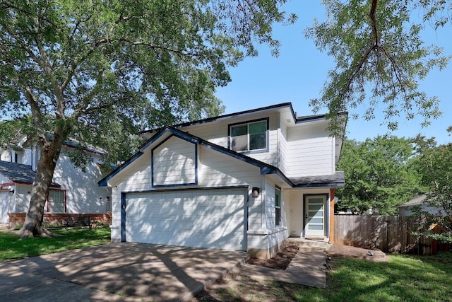 traditional-style home featuring fence, concrete driveway, and a garage