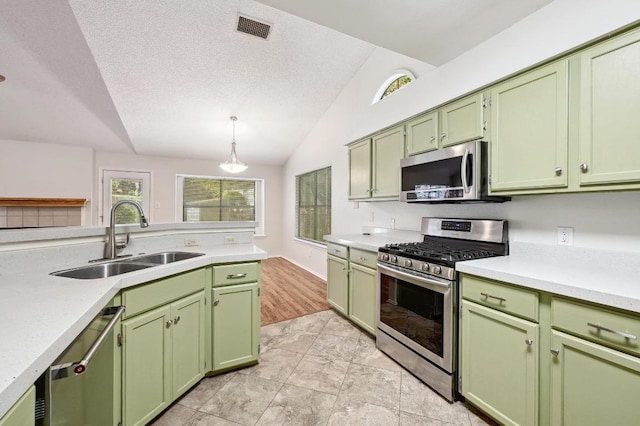 7201 Pine Bluffs Trl, Austin, TX 78729 - kitchen with appliances with stainless steel finishes, green cabinets, a sink, vaulted ceiling, and light countertops