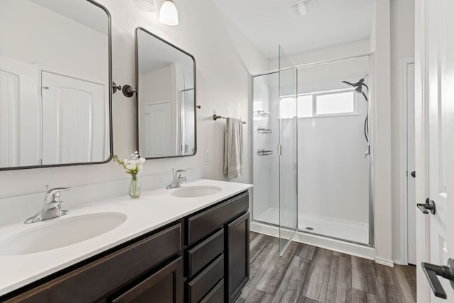 109 Reagor Dr, Taylor, TX 76574 - bathroom featuring a shower stall, double vanity, and wood finished floors