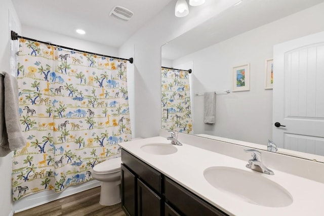 109 Reagor Dr, Taylor, TX 76574 - bathroom with double vanity, wood finished floors, a shower with shower curtain, and recessed lighting