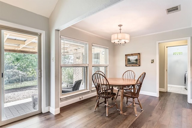dining area with a chandelier, dark wood-style floors, baseboards, and crown molding