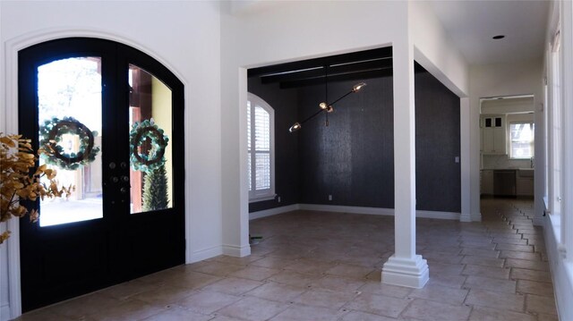 7228 Oak Shores Dr, Austin, TX 78730 - foyer entrance with stone tile flooring, french doors, baseboards, and arched walkways
