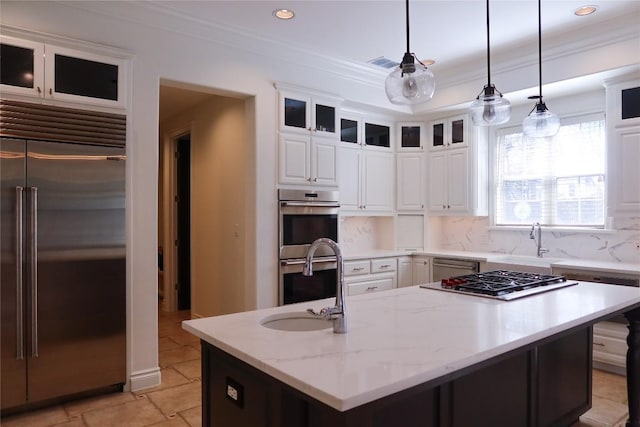 7228 Oak Shores Dr, Austin, TX 78730 - kitchen featuring appliances with stainless steel finishes, a sink, an island with sink, crown molding, and white cabinets