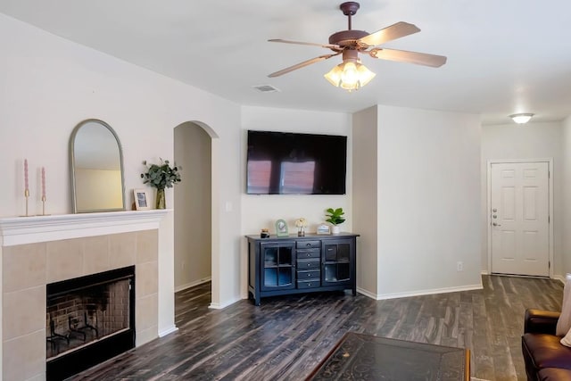 232 Housefinch Loop, Leander, TX 78641 - living room featuring wood finished floors, a ceiling fan, arched walkways, and a tile fireplace