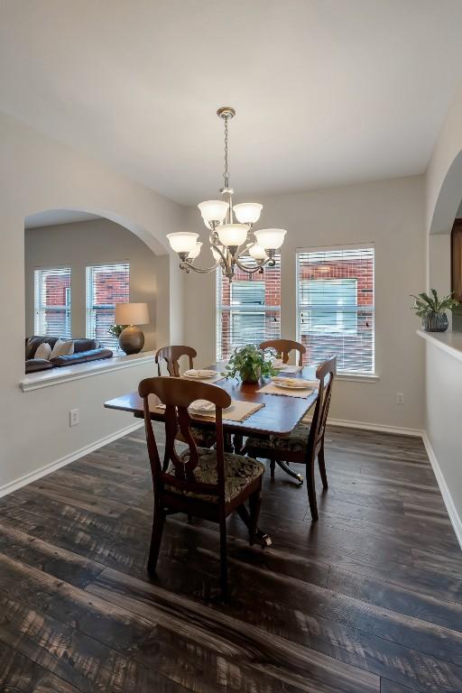 232 Housefinch Loop, Leander, TX 78641 - dining space featuring arched walkways, a chandelier, and dark wood-type flooring