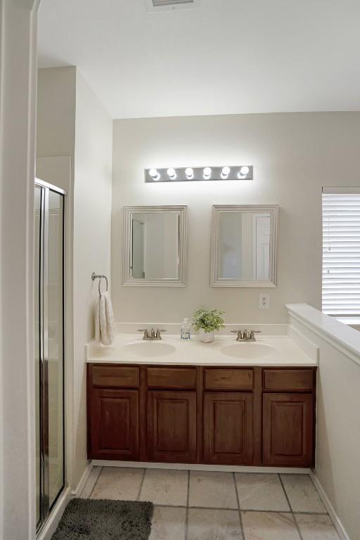 232 Housefinch Loop, Leander, TX 78641 - full bathroom featuring double vanity, a stall shower, and tile patterned flooring