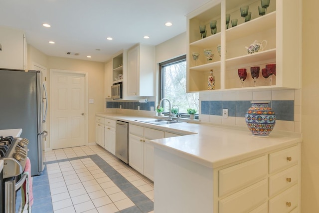 2403 Braemar Cv, Austin, TX 78747 - kitchen featuring open shelves, appliances with stainless steel finishes, a sink, light tile patterned floors, and white cabinetry