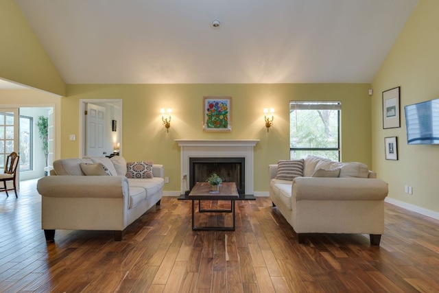 2403 Braemar Cv, Austin, TX 78747 - living room with lofted ceiling, dark wood-style floors, a fireplace with raised hearth, and baseboards