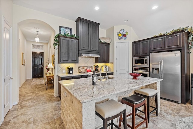 4216 Hannover Way, Round Rock, TX 78681 - kitchen with appliances with stainless steel finishes, arched walkways, a sink, tasteful backsplash, and a center island with sink