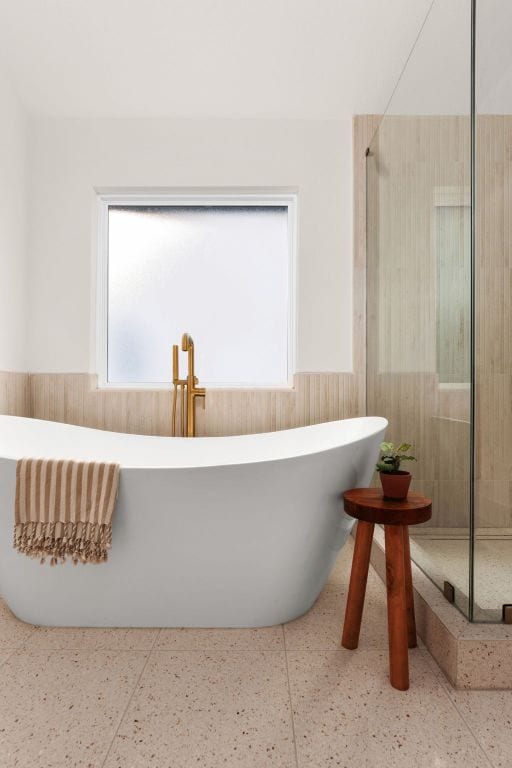 full bath featuring a stall shower, a wainscoted wall, and a freestanding tub