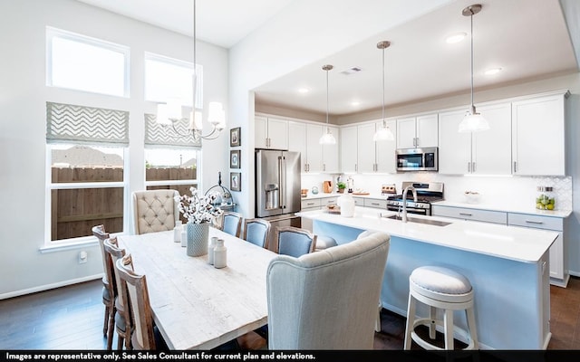 200 Hollister Dr, Liberty Hill, TX 78642 - kitchen with stainless steel appliances, a sink, a breakfast bar area, light countertops, and white cabinetry