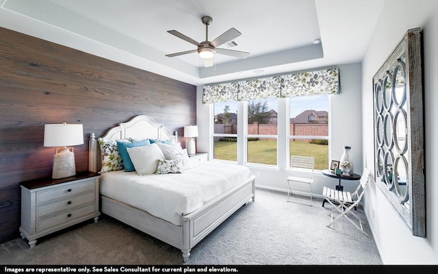 200 Hollister Dr, Liberty Hill, TX 78642 - bedroom with multiple windows, carpet flooring, wooden walls, a tray ceiling, and baseboards