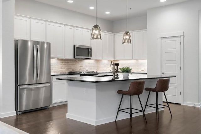 2204 Robert Browning St, Austin, TX 78723 - kitchen with stainless steel appliances, a sink, dark wood-style floors, tasteful backsplash, and a kitchen island with sink
