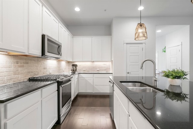 2204 Robert Browning St, Austin, TX 78723 - kitchen with stainless steel appliances, dark wood-style flooring, a sink, tasteful backsplash, and white cabinetry