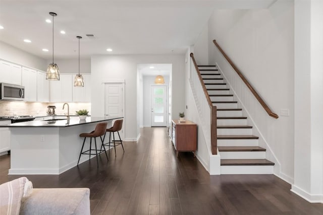 2204 Robert Browning St, Austin, TX 78723 - kitchen featuring stainless steel microwave, dark countertops, dark wood finished floors, a sink, and recessed lighting