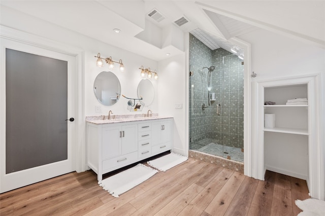 19905 Hamilton Pool Rd, Dripping Springs, TX 78620 - full bathroom featuring double vanity, a shower stall, wood finished floors, a walk in closet, and beamed ceiling