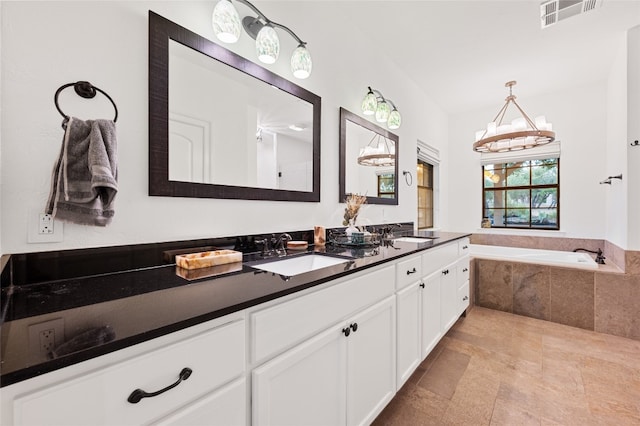 19905 Hamilton Pool Rd, Dripping Springs, TX 78620 - full bath featuring double vanity, a bath, and a chandelier