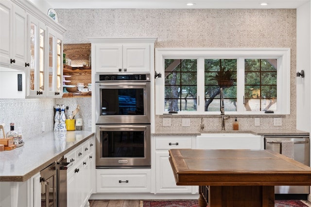 19905 Hamilton Pool Rd, Dripping Springs, TX 78620 - kitchen featuring appliances with stainless steel finishes, beverage cooler, white cabinetry, backsplash, and recessed lighting
