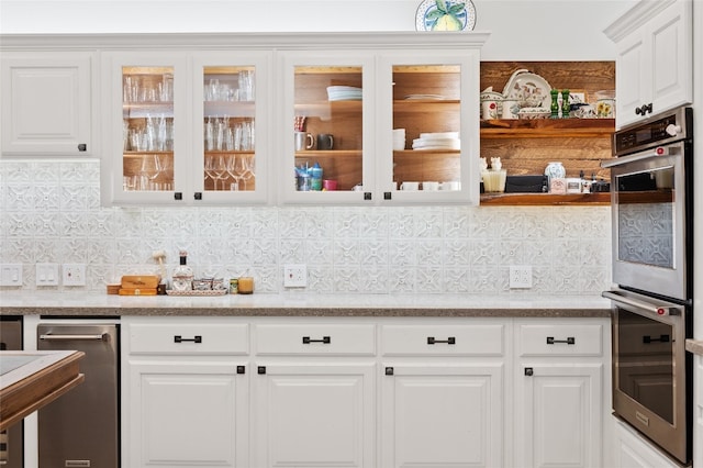 19905 Hamilton Pool Rd, Dripping Springs, TX 78620 - kitchen featuring stainless steel double oven, white cabinetry, tasteful backsplash, and glass insert cabinets