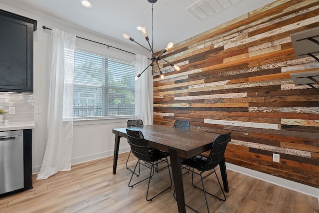 6008 Rubicon Run, Austin, TX 78745 - dining space with a chandelier, wooden walls, light wood finished floors, baseboards, and recessed lighting
