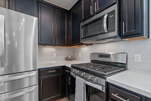 6008 Rubicon Run, Austin, TX 78745 - kitchen with stainless steel appliances, backsplash, light stone counters, and light wood-style flooring