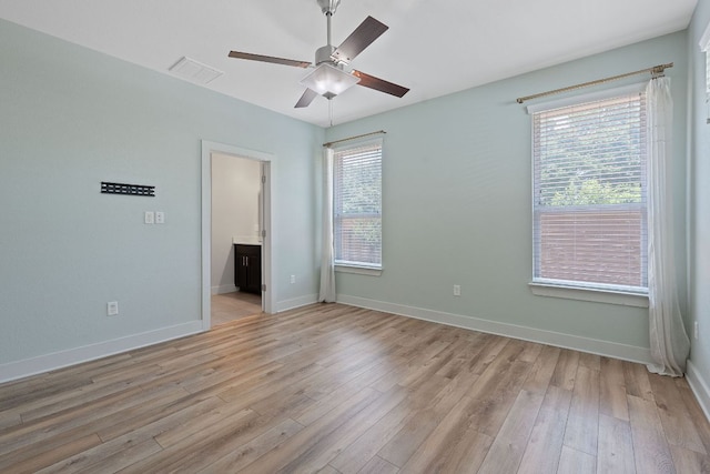 spare room with ceiling fan, light wood finished floors, and baseboards