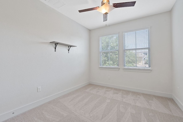 empty room featuring ceiling fan, light carpet, and baseboards