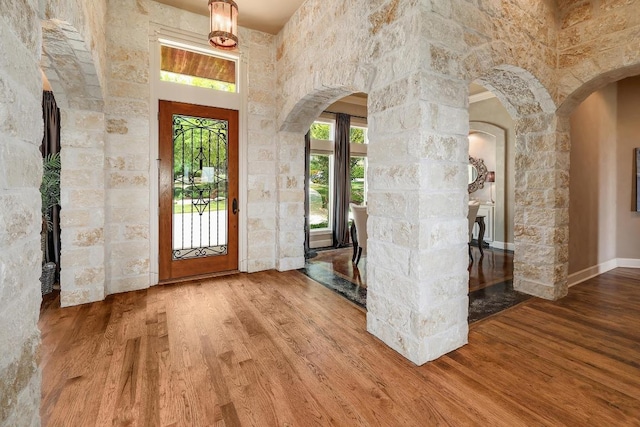 entrance foyer with wood finished floors and arched walkways