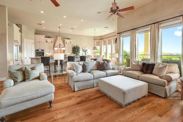 living area with ceiling fan, light wood-style floors, recessed lighting, and healthy amount of natural light