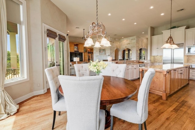 dining area with recessed lighting, light wood-type flooring, a chandelier, baseboards, and arched walkways