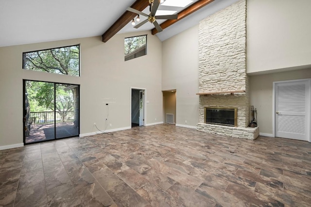 107 Phalarope Dr, Buda, TX 78610 - unfurnished living room with high vaulted ceiling, ceiling fan, beamed ceiling, stone finish flooring, and baseboards