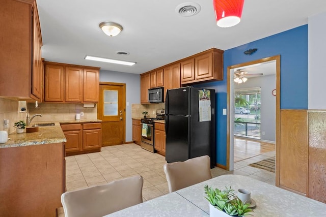 7912 Burrell Dr, Austin, TX 78757 - kitchen featuring appliances with stainless steel finishes, tasteful backsplash, a sink, light tile patterned floors, and brown cabinetry