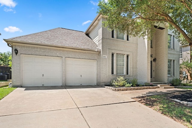 7016 Bending Oak Rd, Austin, TX 78749 - view of front of home featuring an attached garage, brick siding, driveway, a shingled roof, and central AC unit