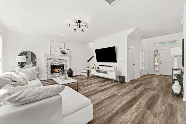 7016 Bending Oak Rd, Austin, TX 78749 - living room featuring a stone fireplace, wood finished floors, stairs, ornamental molding, and baseboards