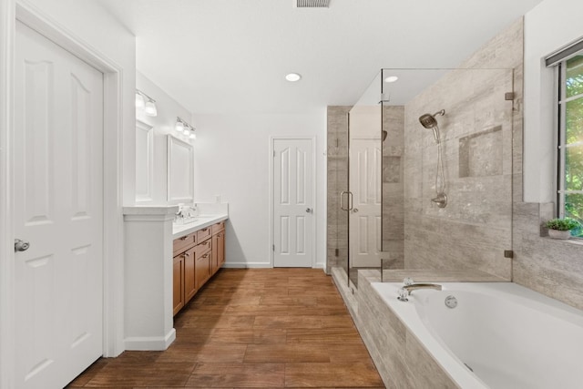 7016 Bending Oak Rd, Austin, TX 78749 - bathroom featuring a stall shower, a bath, vanity, wood finished floors, and baseboards