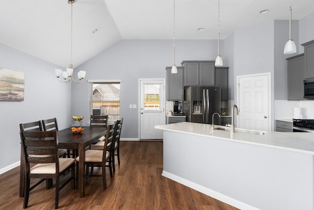 143 Dogvane Cir, Kyle, TX 78640 - dining room with a chandelier, dark wood-style floors, high vaulted ceiling, and baseboards