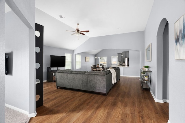 143 Dogvane Cir, Kyle, TX 78640 - living area with arched walkways, vaulted ceiling, dark wood finished floors, ceiling fan, and baseboards