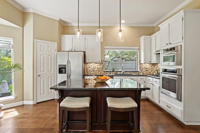 3701 Clendenin Ct, Austin, TX 78732 - kitchen with stainless steel appliances, a sink, backsplash, white cabinets, and a kitchen island