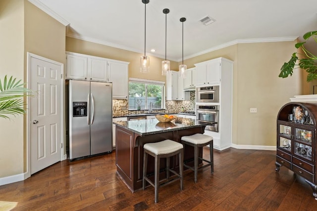3701 Clendenin Ct, Austin, TX 78732 - kitchen featuring appliances with stainless steel finishes, a sink, a kitchen island, backsplash, and white cabinetry