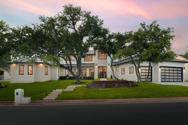1800 Bay Hill Dr, Austin, TX 78746 - view of front of home with stucco siding, a lawn, driveway, and an attached garage