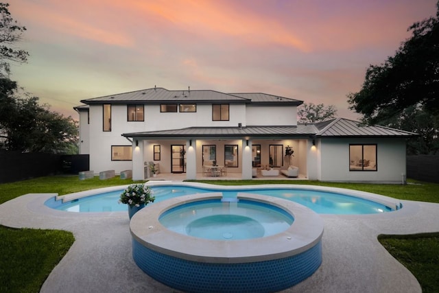 1800 Bay Hill Dr, Austin, TX 78746 - back of property at dusk with a standing seam roof, stucco siding, and a metal roof