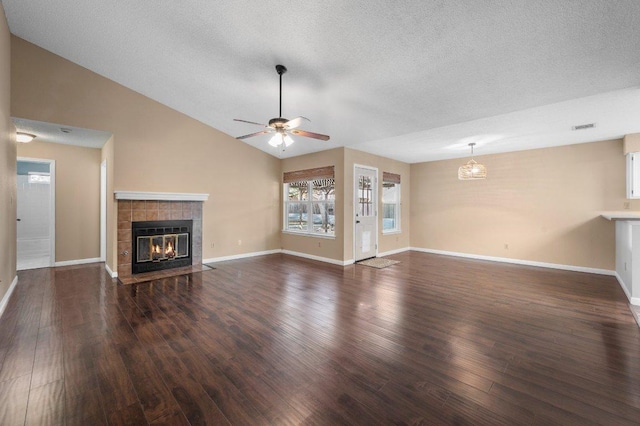 unfurnished living room featuring wood finished floors, a tile fireplace, a ceiling fan, a textured ceiling, and baseboards