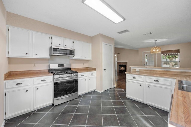 13018 Garfield Ln, Austin, TX 78727 - kitchen with appliances with stainless steel finishes, white cabinetry, light countertops, and a sink