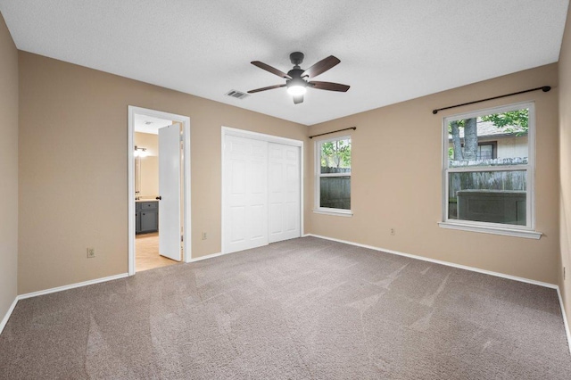 13018 Garfield Ln, Austin, TX 78727 - unfurnished bedroom with baseboards, carpet flooring, a closet, ensuite bath, and ceiling fan