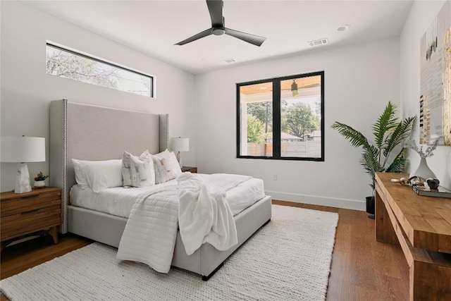 bedroom featuring wood finished floors, a ceiling fan, and baseboards
