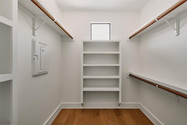 walk in closet with wood finished floors